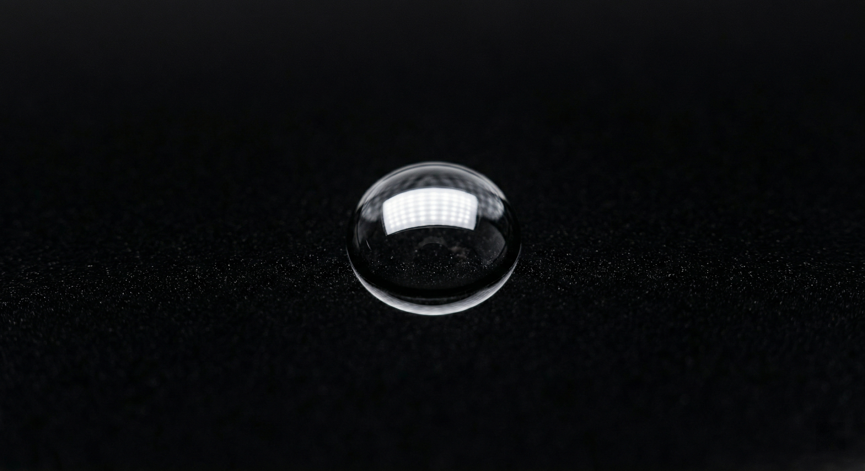 Single perfect water bead on ceramic-coated black paint